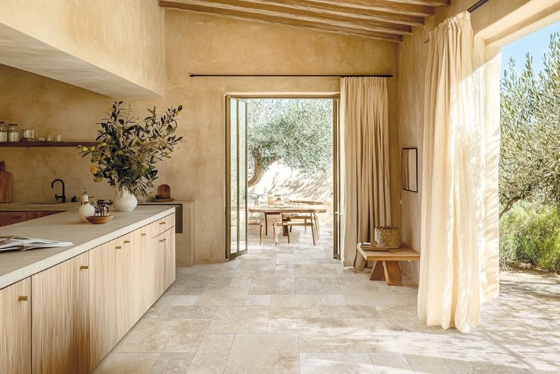 Warm beige travertine floor tiles in a Mediterranean-style kitchen.