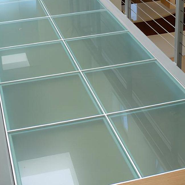 Specialised smoky-grey glass tiles used in a kitchen floor design.